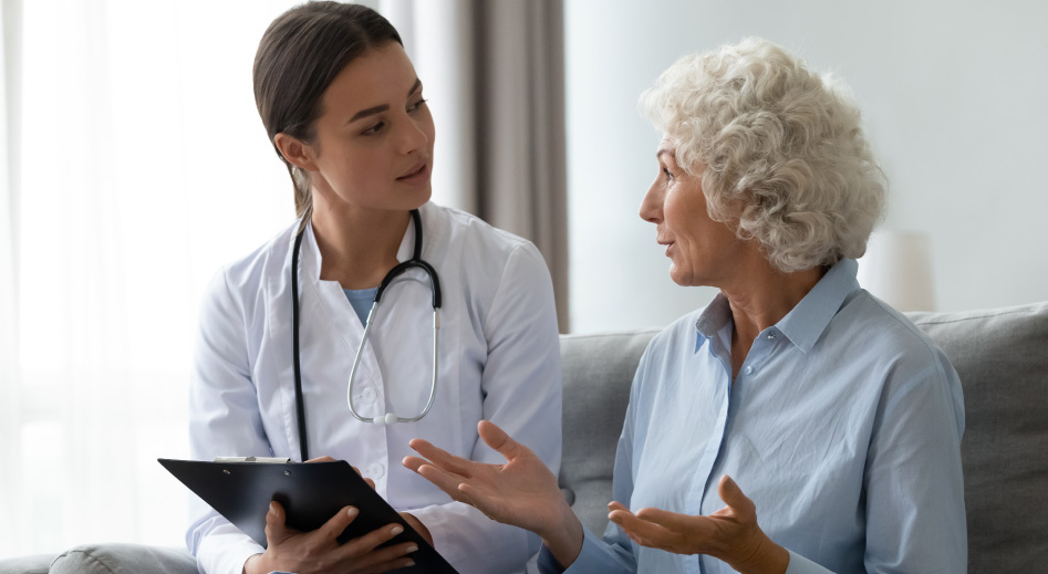 Lekárka odpovedá staršej žene na otázky o osteoporóze.