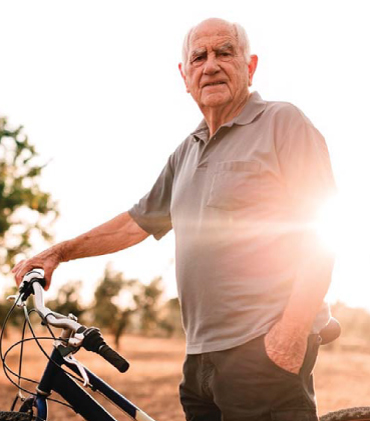 Pavol - pacient s osteoporózou, stojí pri bicykli.